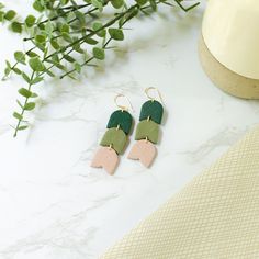 Introducing our exquisite green floral clay earrings, the perfect accessory to complement your wedding day ensemble with timeless elegance. Crafted with utmost care and attention to detail, these stunning earrings feature a soft, neutral hue that effortlessly blends with any wedding theme and attire. The beige clay showcases a subtle, organic texture, adding a touch of natural charm to your overall look. The delicate design exudes sophistication, making these earrings a delightful choice for bri Green Flower Earrings With Ear Wire For Wedding, Green Flower Earrings For Wedding With Ear Wire, Elegant Green Polymer Clay Jewelry, Green Hand-set Bridal Earrings As Gift, Delicate Bridal Earrings, Minimalist Green Polymer Clay Earrings, Green Polymer Clay Flower Drop Earrings, Flower-shaped Polymer Clay Wedding Earrings, Elegant Green Patina Earrings