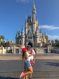 two girls hugging each other in front of a castle at disney world with the sky in the background