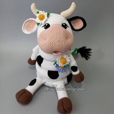 a crocheted cow sitting on top of a gray surface