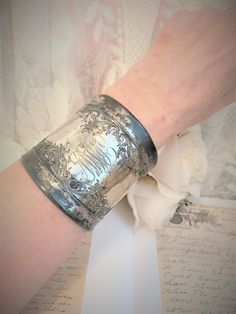 "This is a large cuff made from an old antique silverplated clothes brush.  The antique metal is from the Art Nouveau period 1880-1930, very rustic, silverplated. There are initials but I can't make them out. There is a design engraved lots of swirls and flowers. The silverplated cuff is very rustic with blemishes, flaws and marks of 100 years of use!  Please see pictures, ask questions if you need/want! This cuff is hand forged by myself. It is quite a process as taking apart the clothes brush has to be done with care as the metal can tear and the brush is glued into the metal sometimes with very strange old not always brittle substances, sometimes tarry like gunk which all has to be removed from the metal.  Then the metal edges have to be carefully bent and rolled over all around the ova Silver Bracelet Cuff, Baby Fairy, Bracelet Cuff, Antique Metal, Old Antiques, Silver Cuff Bracelet, The Clothes, Hand Forged, 100 Years