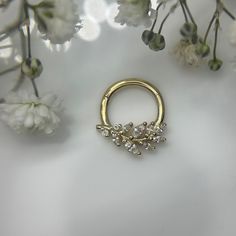 a gold nose ring with three small diamonds