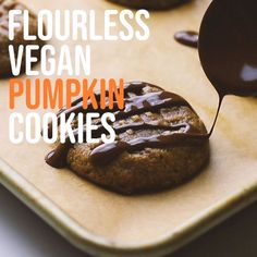 chocolate covered cookies on a baking sheet with the words flourless vegan pumpkin cookies