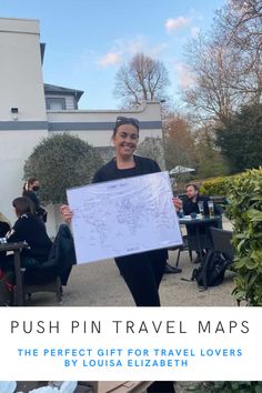 a woman holding up a map with the words push pin travel maps in front of her