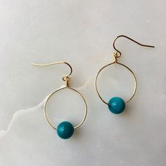 The Mini hoops feature a bright, colorful bead or gemstone of your choice on a round hoop that is wire-wrapped and secured to an elegant ear wire. These hoop earrings are mindfully made with high-quality, gold-plated metals. They are nickel-free and safe for sensitive ears. If you have additional allergies, please contact me before purchasing. I have sterling silver, gold-filled, or hypoallergenic titanium ear wires available by request. The earrings are approximately 1 3/4" long x 1" wide, incl Gift Hoop Earrings With Natural Stones, Hoop Earrings With Round Natural Stones For Gift, Everyday Hoop Beaded Earrings With Ear Wire, Wire Wrapped Round Beaded Earrings, Everyday Wire Wrapped Beaded Dangle Earrings, Small Wire Wrapped 14k Gold Filled Hoop Earrings, Small 14k Gold Filled Wire Wrapped Hoop Earrings, Blue Small Hoop Earrings Wire Wrapped, Blue Small Hoop Earrings With Wire Wrapping