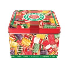 a red and green lunch box filled with lots of candy canes on top of it