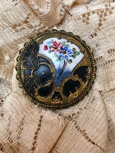 "Circa 1905, Gibson Girl Late Victorian Brioch-Pendant Combination that MAY have been a button at one time. Stunning gilded Gold over black enamel Flowers w/hand-painted enamel with petit-fleurs. Twist border, measures 1 3/8\" diameter. The bale is mounted on a swivel so it can be folded under. Outstanding condition." Gold Enamel Art Nouveau Brooches, Vintage Black Enamel Pin For Gift, Victorian Enamel Brooches For Formal Wear, Victorian Enamel Brooches For Formal Occasions, Antique Enamel Brooches For Formal Occasions, Antique Gold Enamel Pin Gift, Victorian Style Enamel Brooches For Formal Occasions, Vintage Black Enamel Jewelry, Vintage Black Collectible Brooches