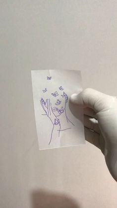 someone holding up a piece of paper with a drawing on it