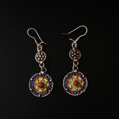 These exquisite handcrafted earrings showcase the rich cultural heritage of the Moroccan Amazigh people. Made from sterling silver, these dangle earrings feature a unique design with two circular elements connected by delicate links. The upper circle is adorned with intricate silver beadwork, while the larger lower circle displays vibrant enamel work in shades of blue, green, and yellow, surrounding a striking red stone accent. Dimensions & Weight: Length: Approximately 7.1 cm (2.8 inches) Width Traditional Earrings With Artistic Design For Festivals, Fusion Style Sterling Silver Danglers, Traditional Artistic Design Earrings For Festivals, Artisan Drop Earrings With Artistic Design, Artisan Sterling Silver Jewelry For Festive Occasions, Artistic Metal Drop Earrings, Traditional Sterling Silver Drop Earrings, Nickel Free Fusion Drop Earrings, Nickel-free Fusion Style Drop Earrings