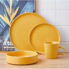 a yellow dinnerware set on a wooden table