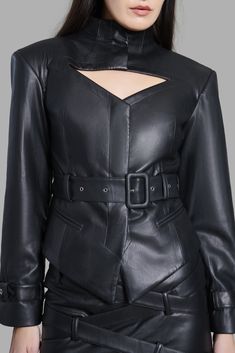 This high-neck faux leather blazer is designed with a chest cut-out, belted sleeves, and a diagonal bottom. The blazer has two pockets and a waist-belt to accentuate your waist. This product is styled with the Black Faux Leather Belted Mini Skirt Fitted Chic Leather Jacket With Belt Loops, Chic Fitted Leather Jacket With Belt Loops, Edgy Fitted Belted Leather Jacket, Chic Long Sleeve Leather Jacket With Belt, Fitted Belted Leather Jacket For Office, Formal Fitted Belted Leather Jacket, Chic Leather Jacket With Belt For Work, Faux Leather Blazer, Cut Blazer