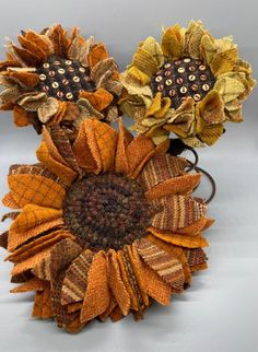 two decorative sunflowers are sitting side by side