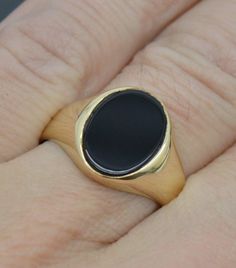 Elevate your style with this classic signet ring, crafted from real solid 14K yellow gold and featuring a sleek oval black onyx stone. This versatile ring is available in all sizes, offering a sophisticated look that's perfect for any occasion. Material: Real Solid 14K Yellow Gold Stone: Oval Black Onyx Design: Classic Signet Available in All Sizes Pendant Details: Style: Signet Metal: 14k Gold  Metal Purity: 14k Metal stamped : 14k Polished: Shiny Width: 15mm Weight: 4.6 Gram Minimalist Oval Cabochon Signet Ring For Formal, Minimalist Oval Cabochon Signet Ring For Formal Occasions, Formal Black Oval Cabochon Signet Ring, Elegant Black Oval Signet Ring, Classic Black Oval Cabochon Ring, Black Oval Signet Ring For Formal Occasion, Formal Black Oval Signet Ring, Classic Gold Onyx Rings, Classic Yellow Gold Onyx Rings