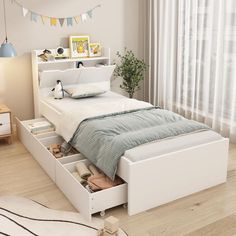 a white bed with drawers underneath it in a bedroom