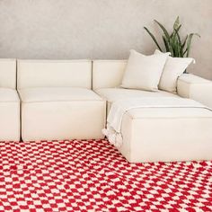 a large white couch sitting on top of a red and white checkered flooring