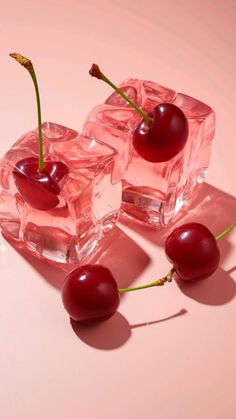 three cherries sitting on top of ice cubes