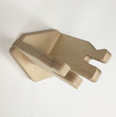 three wooden utensils sitting on top of each other in front of a white wall