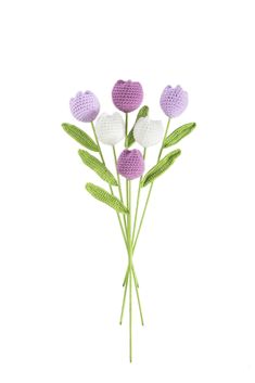 crocheted flowers are arranged on top of each other in purple, white and green