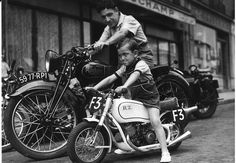 a young boy riding on the back of a motorcycle next to an older man in front of a store