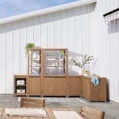 a wooden table sitting next to a white building