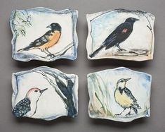 four small ceramic coasters with birds painted on the sides and one bird sitting on a tree branch