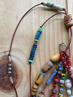 In this Boho beaded necklace I added many beads to a strand of brown leather; including Swarovski crystals, glass, silver, antique, Budha prayer, African Christmas love and colorful seed beads, pearls, ceramic, and powder glass African beads made by the people of Krobo Mountain, in Ghana (they recycle glass bottles, turn them into powder then put in molds, then painted with paste made of colored glass powder and water, then fired twice to fix the decor.  I also added charms; a heart, star, bronz Bohemian Brown Lariat Beaded Necklaces, Adjustable Eclectic Beaded Necklace, Artisan Brown Spacer Beads, Hand-strung Bohemian Lariat Beaded Necklaces, Adjustable Artisan Dangle Beads, Bohemian Hand-strung Lariat Beaded Necklace, Bohemian Lariat Beaded Necklace Hand-strung, Bohemian Brown Hand-strung Beaded Necklaces, Unique Brown Beads For Festivals