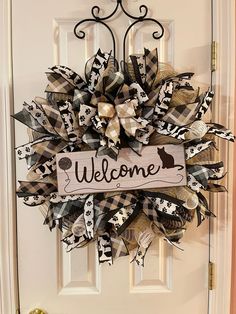 a welcome sign hanging on the front door of a house with dog and bow decorations