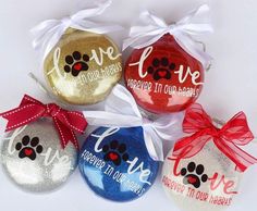 four ornament shaped like christmas ornaments with dog's paw prints on them