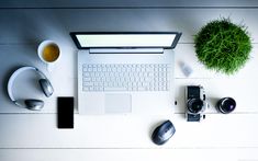 a laptop computer sitting on top of a white desk