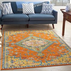 a living room with a blue couch and orange rug