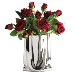 a vase filled with red roses on top of a white table