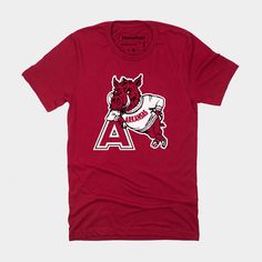 In all of college sports, there’s only one school that can call a razorback their mascot. This wild hog playing it cool in an Arkansas sweater was used by the University of Arkansas from the late 1950s all the way into the 2000s. Pick up our comfy crimson tee and stand out from the crowd the next time you “call the hogs” down in Fayetteville. Brought to you in partnership with College Vault. Vintage Arkansas, Arkansas Razorback, Wild Hog, University Of Arkansas, Arkansas Razorbacks, The 2000s, College Sports, Arkansas, University