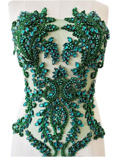 the back of a dress with green beading and beads on it's chest