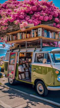 an old vw bus with books on the roof parked in front of a tree