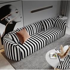 a black and white striped couch sitting on top of a gray rug next to a table