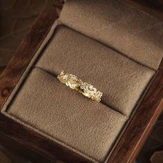 a gold ring sitting on top of a wooden box