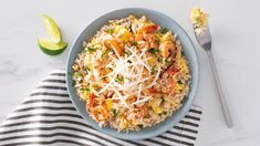 a blue bowl filled with rice and shrimp next to a fork on top of a striped towel