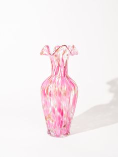 a pink glass vase sitting on top of a white table