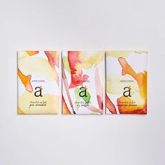 three cards with watercolor designs on them