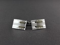 IMPORTANT I will be away from Friday December 8th until Friday December 15th. Please note that during this time period orders will not be processed or shipped. Everything ordered within this time period will be shipped on Saturday December 16th. Thank you for your patience. Made by Anton Michelsen, this is a classy pair of sterling silver engraved rectangular cufflinks. The shiny, reflective cufflinks have a lined center and flowing scrolls on the top and bottom borders. The shank is attached to the back of the cufflinks at an angle. The silver is bright and even in color, and any variance is a reflection. A nice size, they measure 3/4 inch wide, 1/2 inch tall and 1/16 inch thick. They weigh 8.9 grams. The cufflinks are in very good vintage condition. The shank of each cufflink is signed S Elegant Engraved Cufflinks, Luxury Silver Rectangular Cufflinks, Elegant Engraved Cufflinks For Business, Luxury Rectangular Cufflinks With Polished Finish, Formal Silver Engraved Cufflinks, Elegant Engraved White Gold Cufflinks, Elegant Rectangular Cufflinks For Formal Occasions, Elegant Rectangular Cufflinks With Polished Finish, Silver Engraved Cufflinks For Business