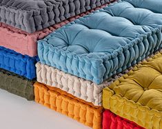 four different colors of pillows stacked on top of each other in the shape of a rectangle