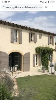 an image of a house with shutters on the front and side windows in grey