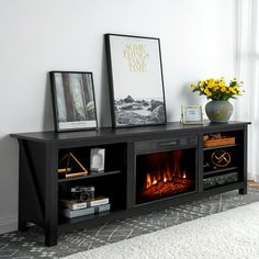 an entertainment center with a fire place and pictures on the top shelf in front of it