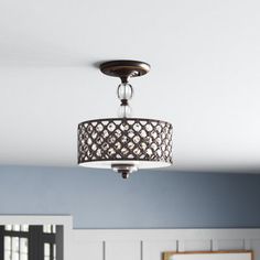 a chandelier hanging from the ceiling in a room with blue walls and white paneling