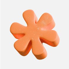 an orange flower shaped object on a white background