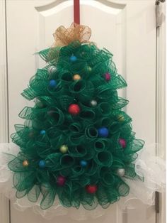 a green christmas tree hanging on the front door