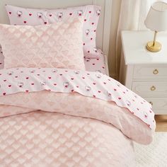 a pink bed with hearts and sheep on it