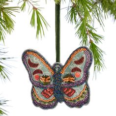 a colorful butterfly ornament hanging from a tree