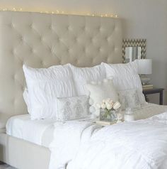 a white bed topped with pillows and blankets