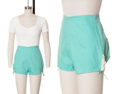 "♡ PLEASE ENLARGE PHOTOS FOR MORE DETAIL ♡ D E T A I L S * 1940s shorts * mint green cotton * high waisted * darts on lower back for a booty-hugging fit * side slits trimmed with lace + adjustable ties * cute lace patch on back * metal back zipper + buttoned tab * unlined * label: Sanforized (pre-shrunk cotton) M E A S U R E M E N T S fits like a: small waist: 25\" hips: 37-39\" (adjustable with ties) length: 12.25\" inseam: 1.5\" front rise: 13\" back rise: 16.5\" leg width: 20-24\" (adjustable with ties) C O N D I T I O N Very good vintage condition. Freshly cleaned and ready to wear! One super small area at base of zipper flap that is ever-so-slightly faded but goes unnoticed while worn. The lace patch appears to be a newer addition to cover a stain, but I think it looks real cute and a 1940s Shorts, Beautiful Jumpsuits, Tie Length, Summer Hot, Small Waist, Green Cotton, First Class, Short Outfits, Mint Green