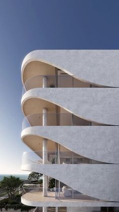 an architecturally designed building on the beach with people walking around it and looking out at the ocean